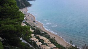 A coastal area with a beach, houses along the shore, and a road leading to the beach. - Corfu Island Apartment 86 (Corfu)