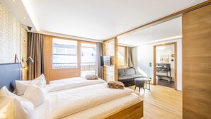 Ett modernt hotellrum med en stor säng, ett skrivbord och en balkong.