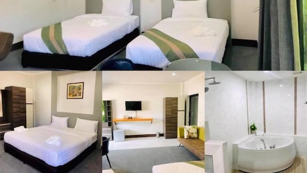 Een hotelkamer met twee bedden, een kroonluchter, een schilderij, een televisie en een badkamer met een bad.