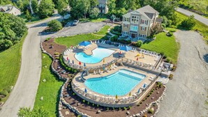 A large, multi-pool resort with a central swimming pool, surrounded by lounge areas and a landscaped garden. - Pool&SplashPad Hot Tub PoolTable, Foosball, Lake, Shows, Golf, Shop, FUN (Hollister)