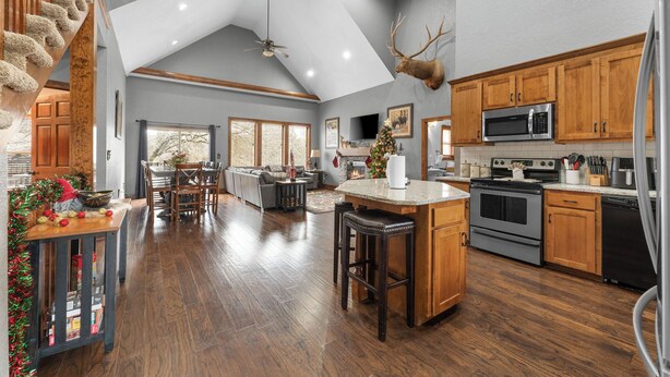 A spacious kitchen with wooden cabinets, a large island, and a mounted deer head. - Pool&SplashPad Hot Tub PoolTable, Foosball, Lake, Shows, Golf, Shop, FUN (Hollister)