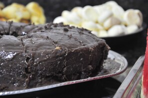 A chocolate cake with a glossy chocolate glaze on a silver platter.