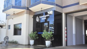 Exterior del Hotel Guadagnini con diseño moderno, destacando una fachada negra, amplios ventanales y plantas en macetas al frente.