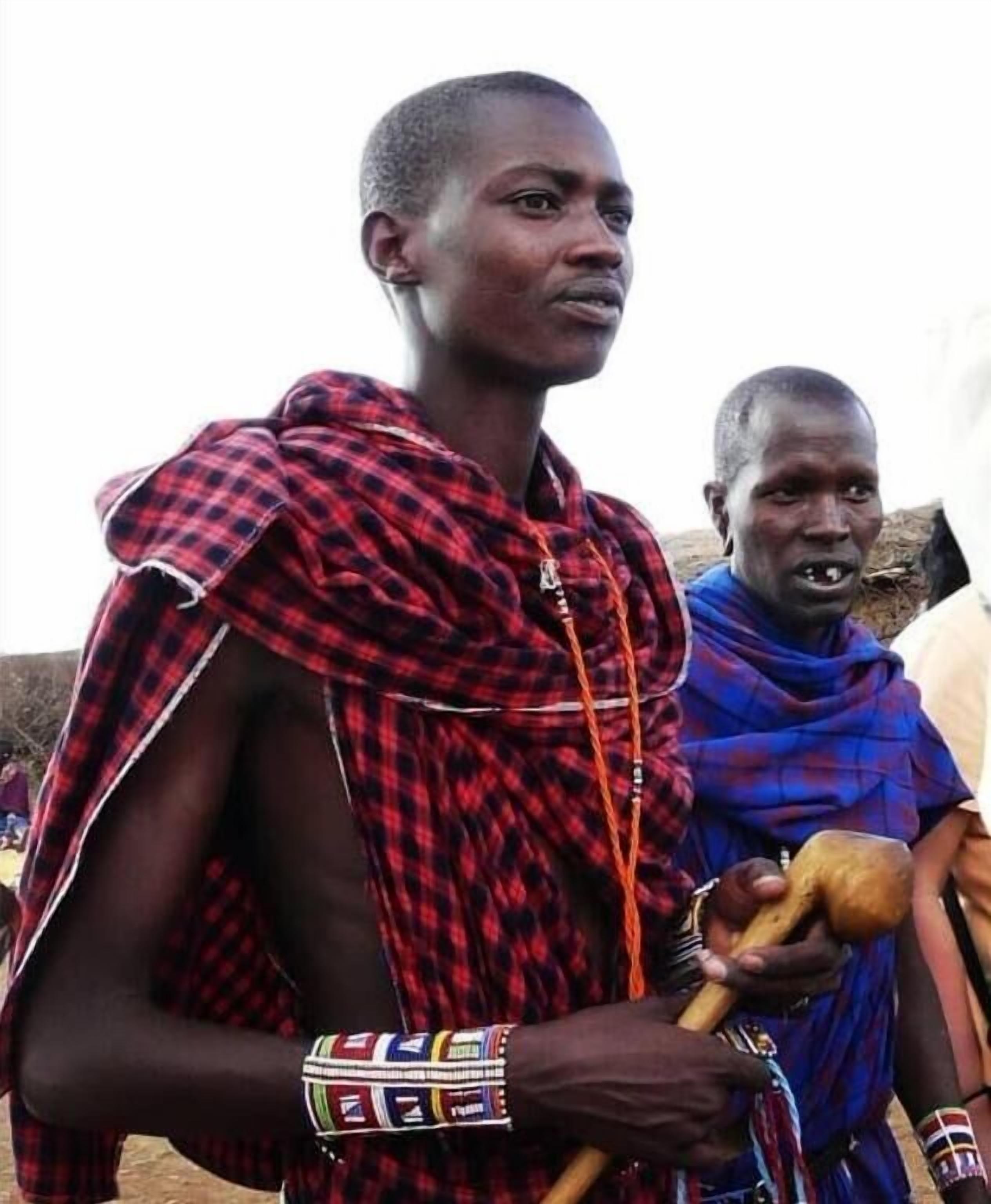A person wearing a red and black checkered garment with a patterned bracelet.