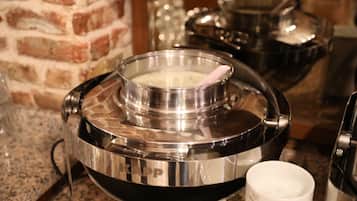 Una cocina con electrodomésticos de acero inoxidable, una pared de ladrillo y una encimera de granito.