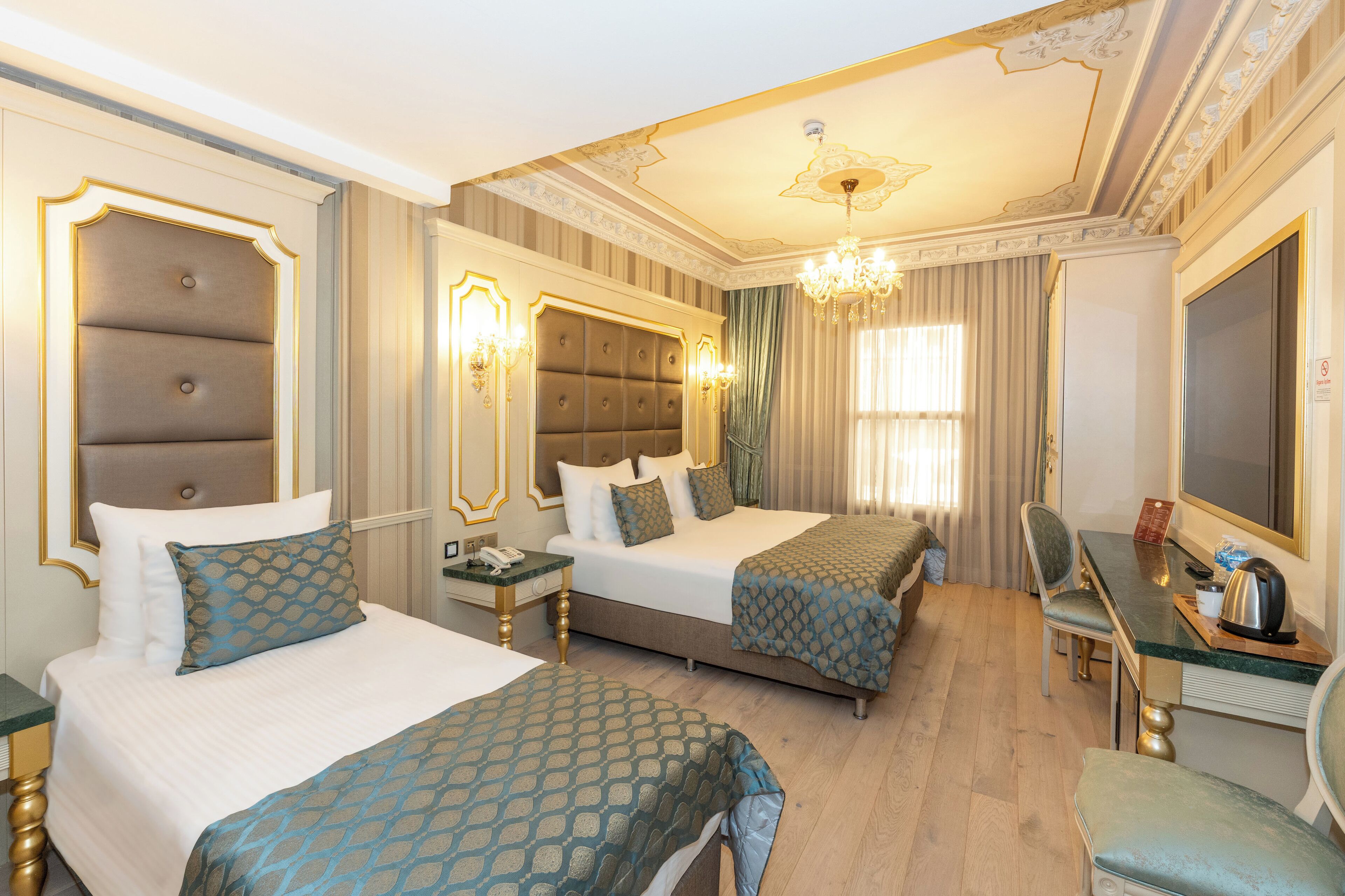 Une chambre d’hôtel avec deux lits, un bureau, une chaise et un grand miroir.