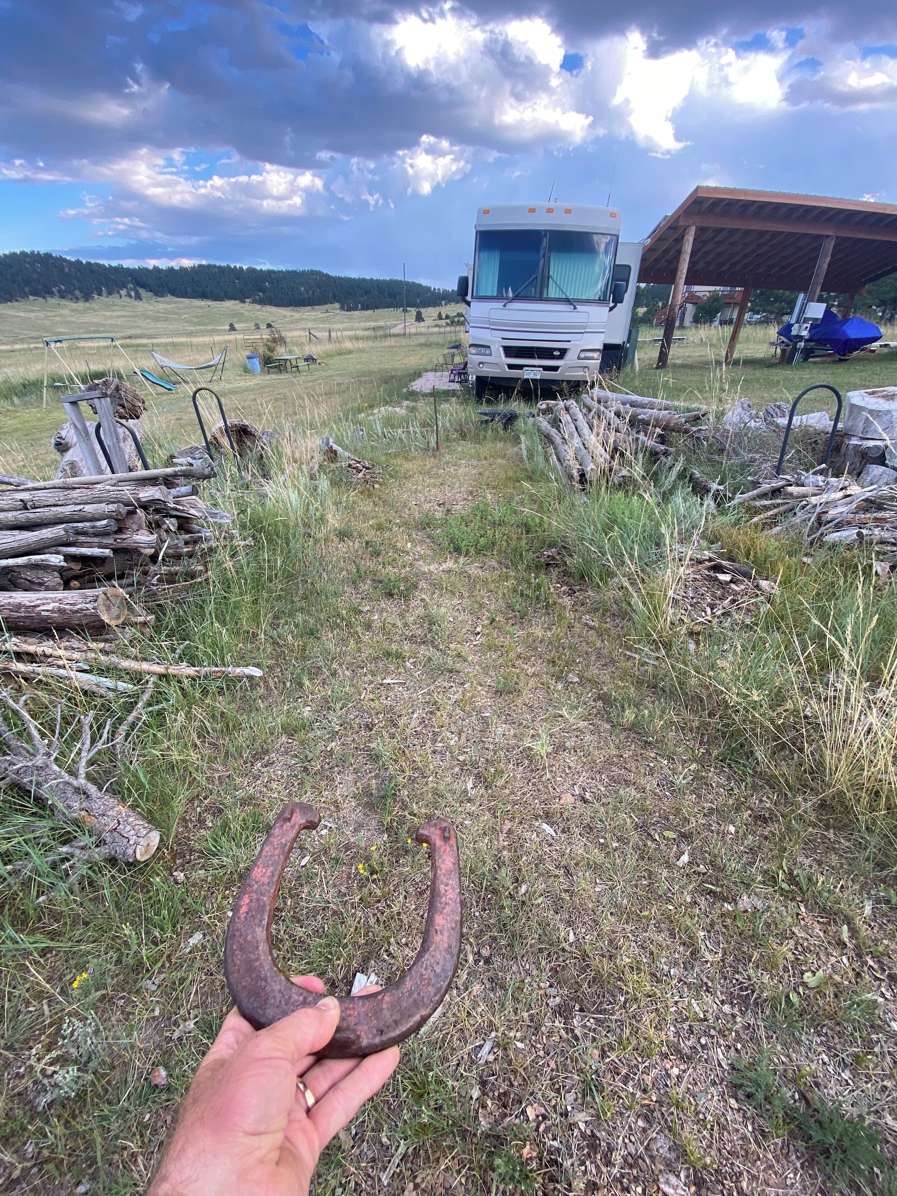 Camp de gespa amb un camió blanc i una estructura coberta al fons.