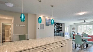 A kitchen with a granite countertop, white cabinets, and teal pendant lights. - Lake Keowee Resort Condo w/ Balcony & Pool Access! (Salem)