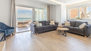 A modern living room with two sofas, a coffee table, and a view of the sea. - Luxury Apartment with Hot tube! Villa Collis (Makarska)