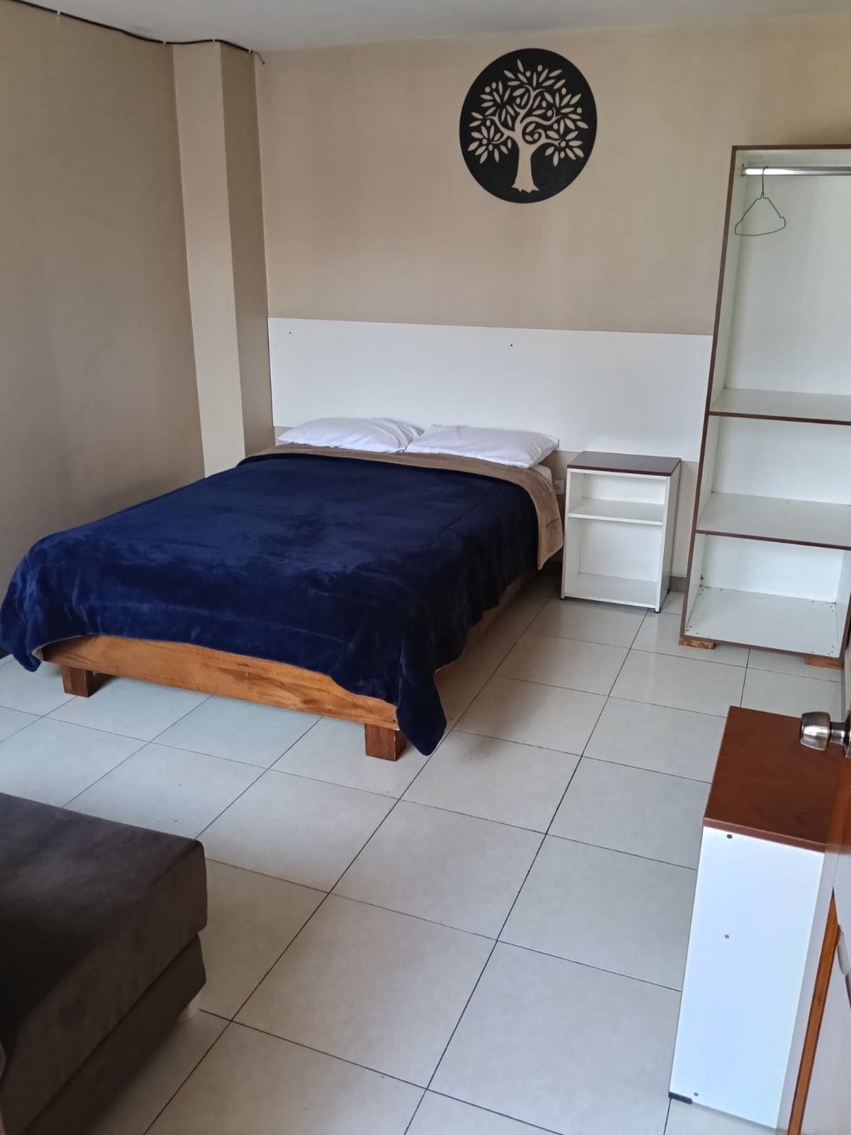 A bedroom with a bed, nightstands, a dresser, and a wall art piece.
