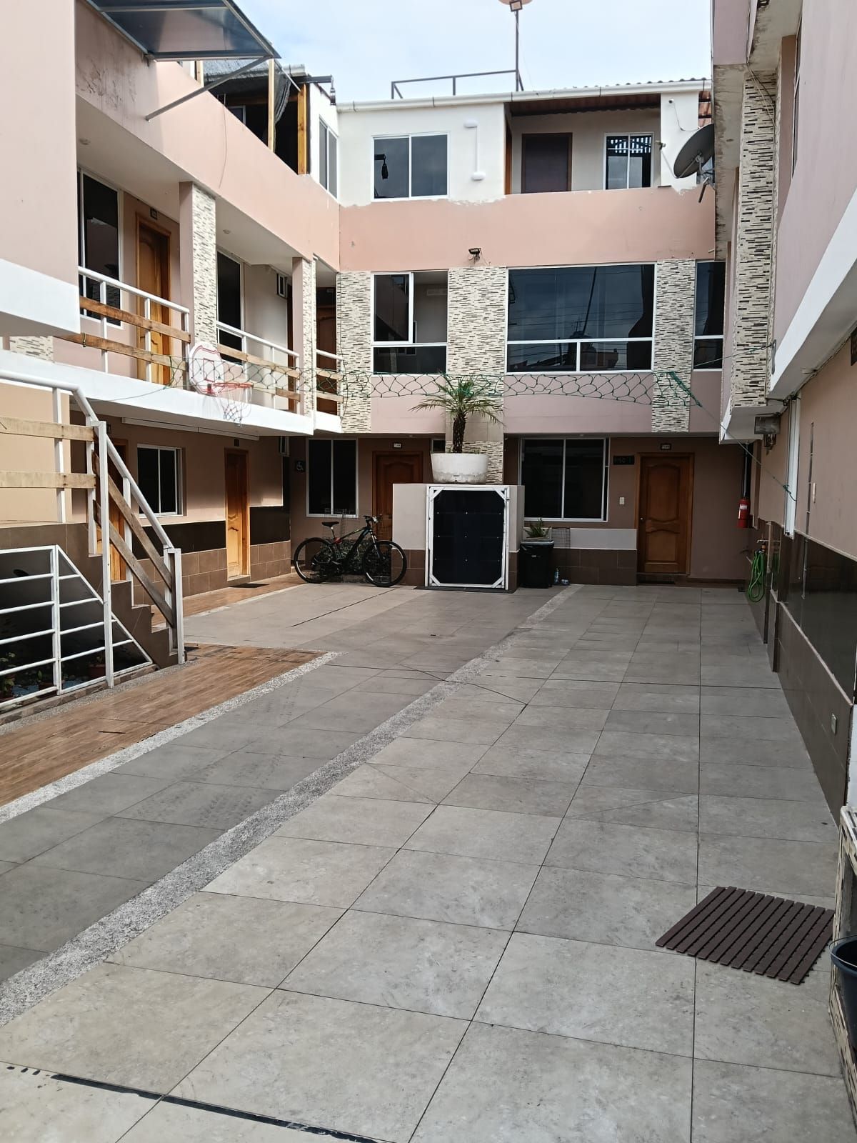 A multi-level building with a central courtyard, a staircase, and a bicycle.