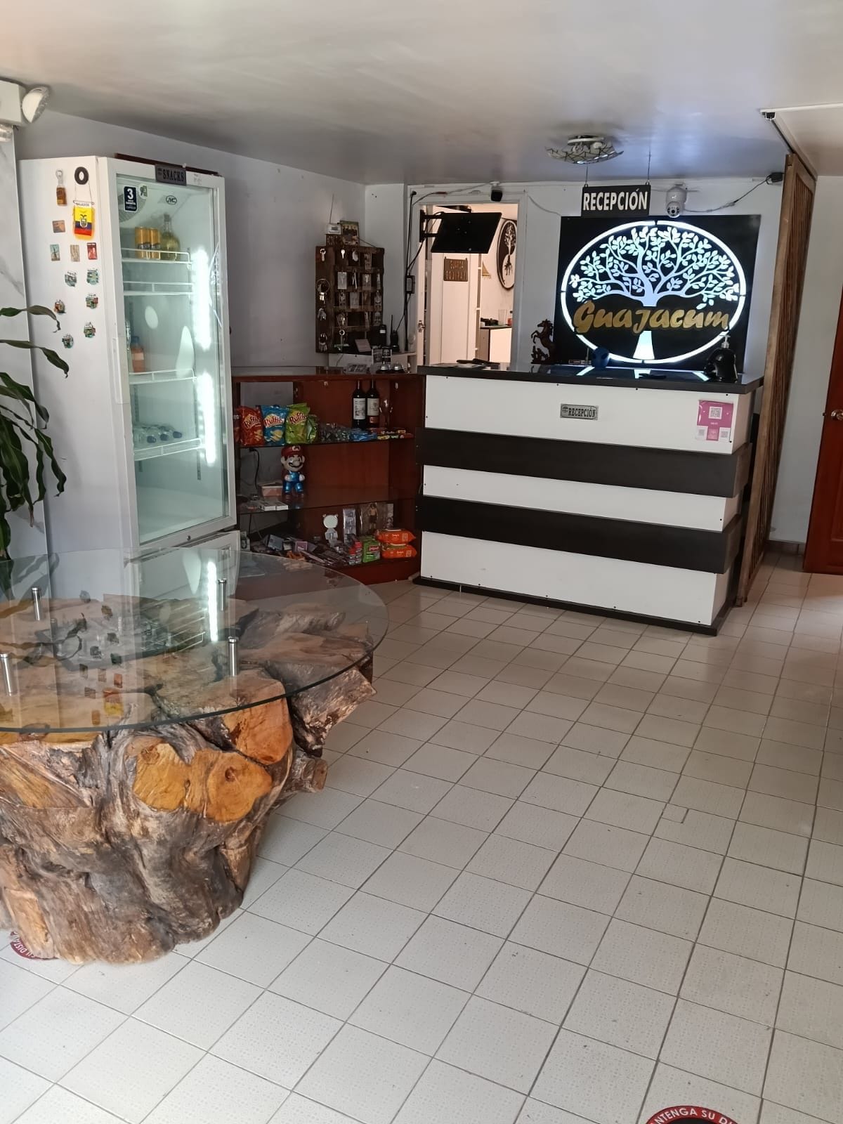 A reception area with a glass display case, a reception desk, and a tiled floor.