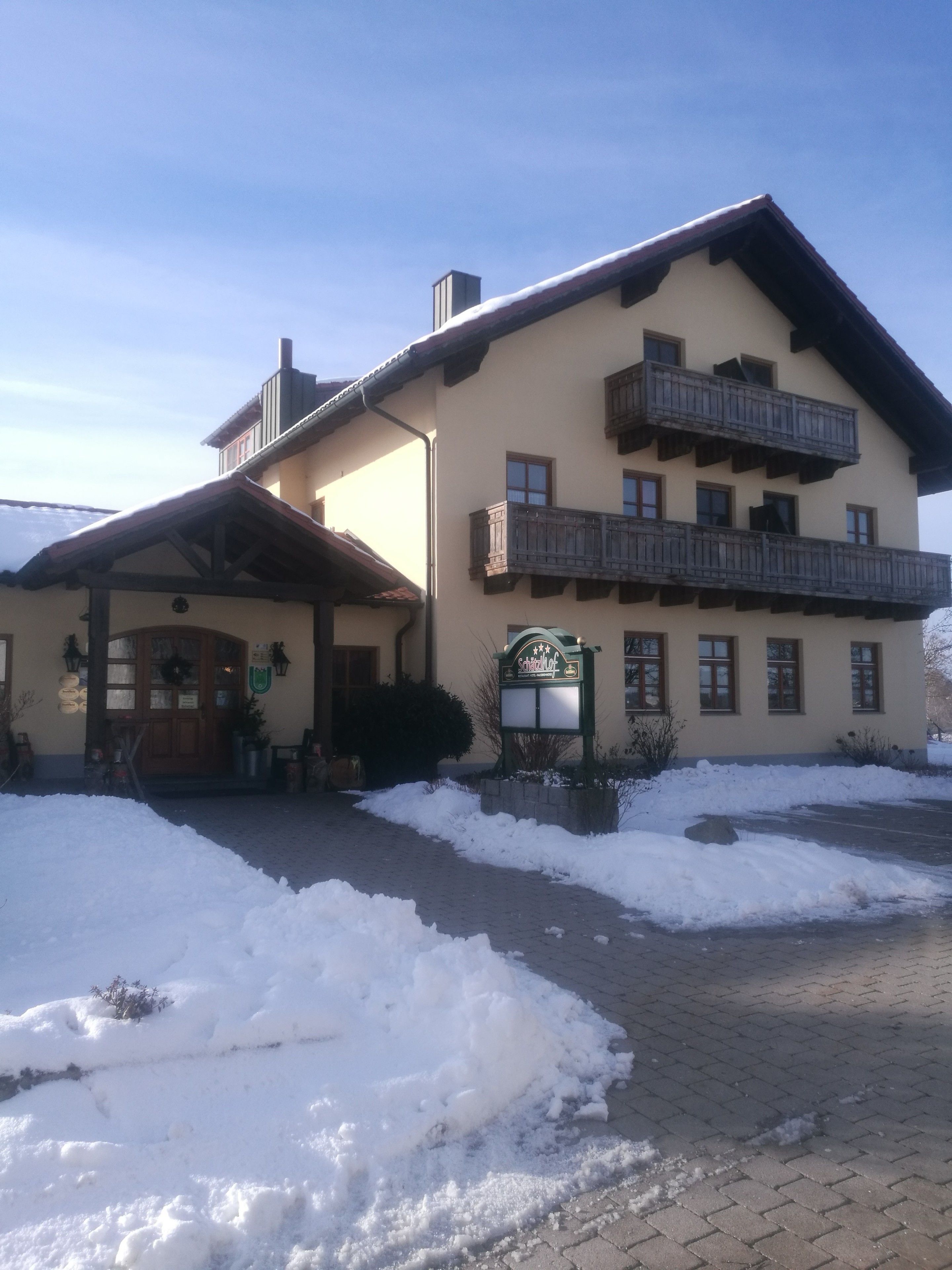 A two-story building with a snow-covered entrance and a sign that reads "Hotel".