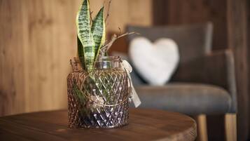 Un florero de vidrio con una planta sobre una mesa de madera.