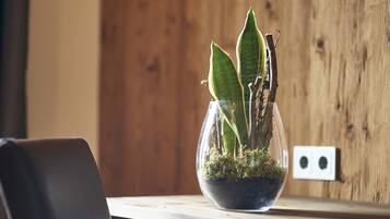 Una planta en test amb un escriptori de fusta i una decoració en forma de cor a la paret.
