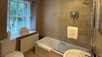 A bathroom with a toilet, a bathtub, a sink, and a shower.