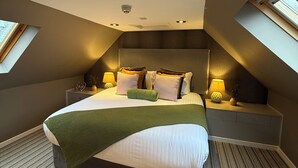 A modern bedroom with a large bed, two bedside tables with lamps, a skylight, and a ceiling light. - Craigatin House & Courtyard (Adults only) (Pitlochry)