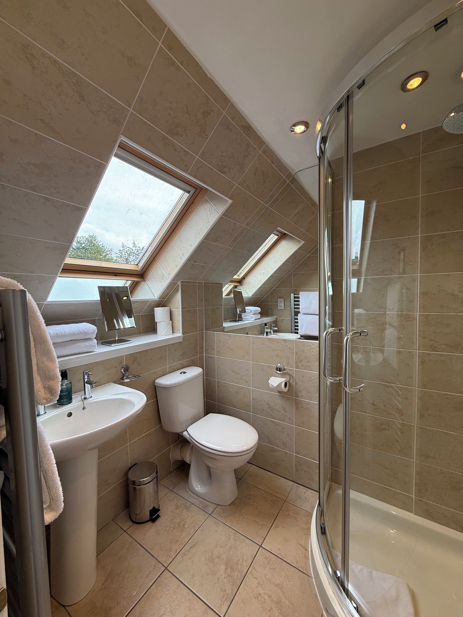 Un baño moderno con tragaluz, ducha y retrete.