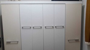 Une armoire blanche avec plusieurs portes et tiroirs.