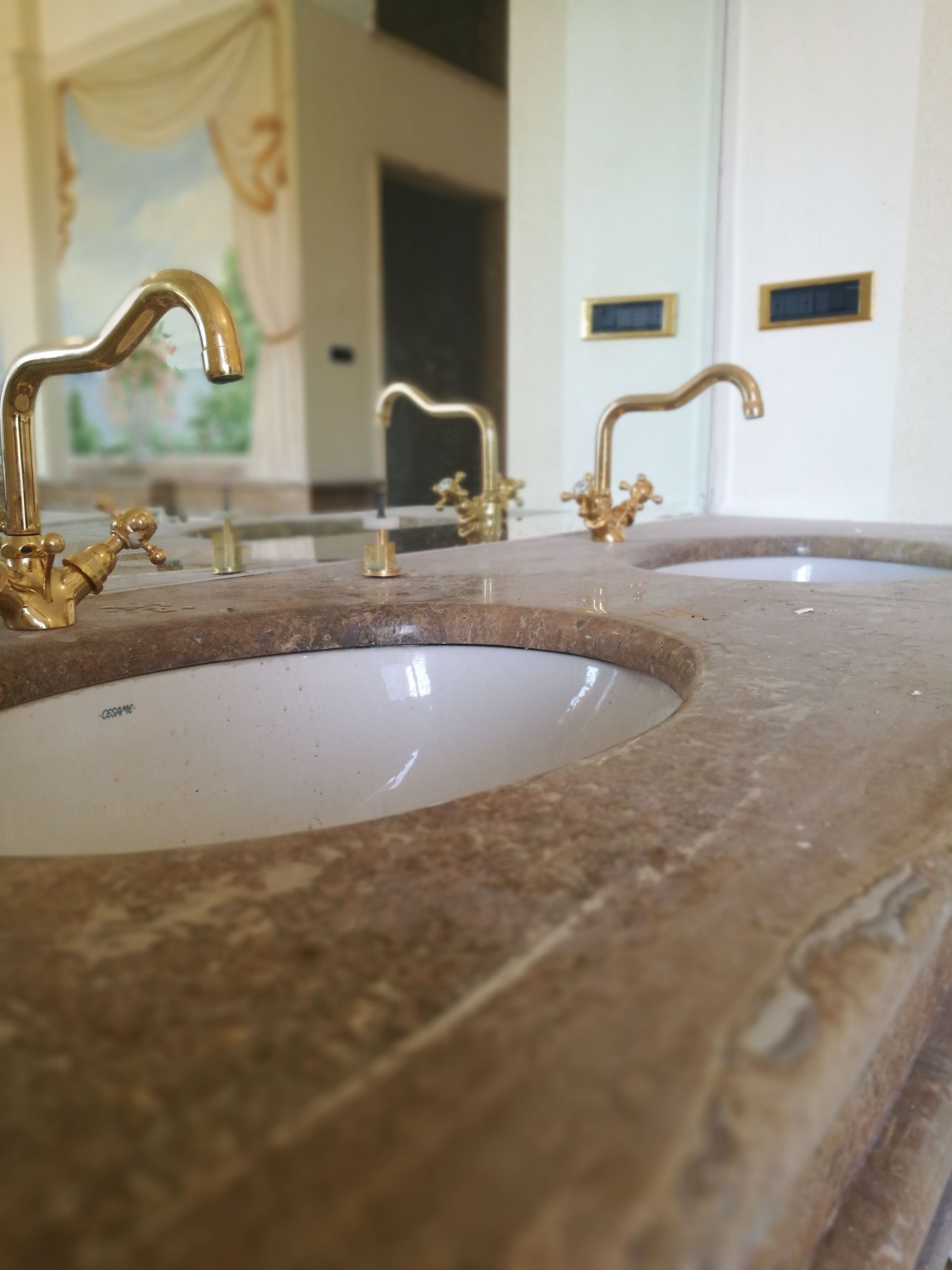 Ein Badezimmer mit zwei Waschbecken, jeweils mit einem Goldarmaturen und einer Marmorarbeitsplatte.