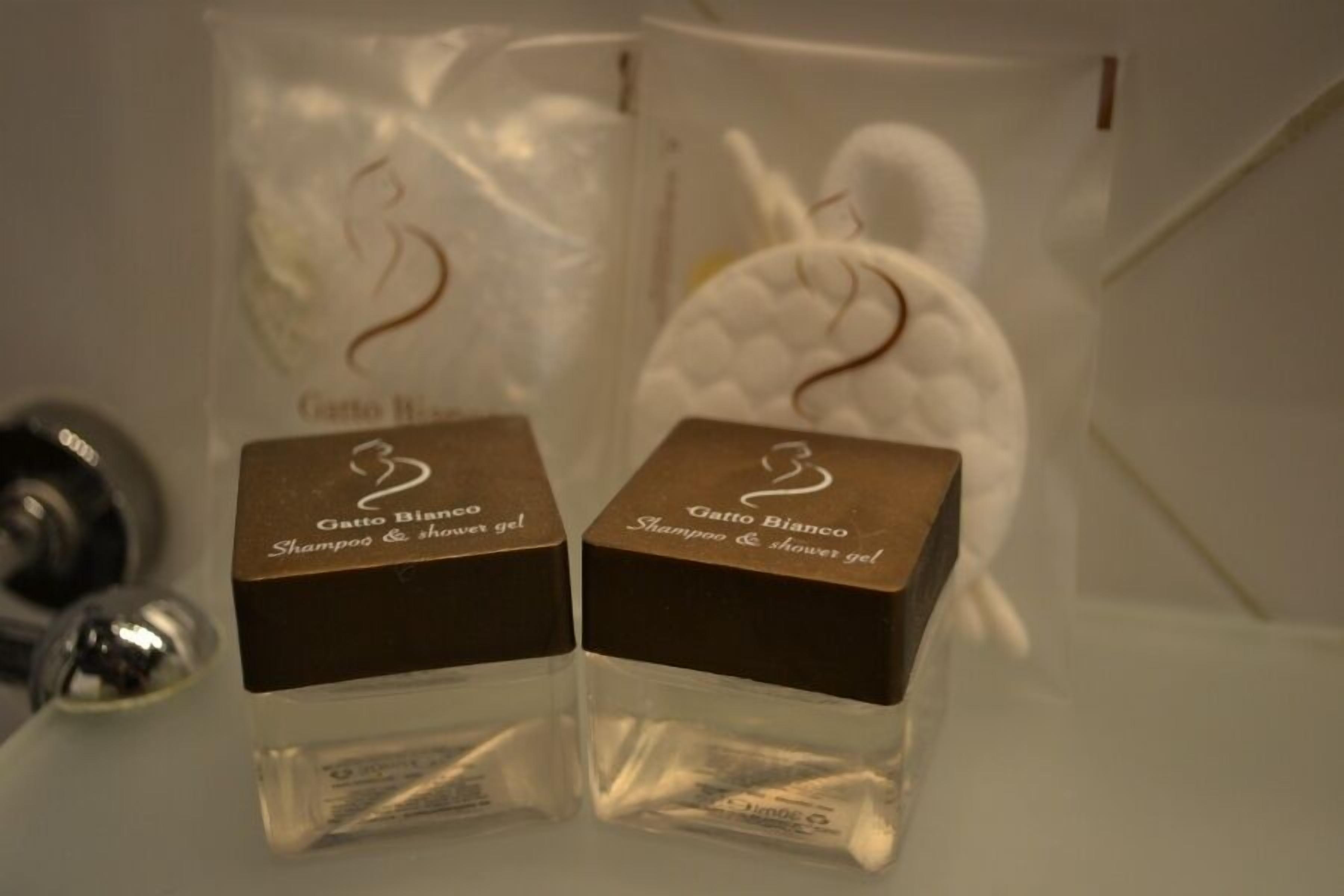Two clear plastic containers with brown lids, each labeled 'Gatto Bianco Shampoo & shower gel'.