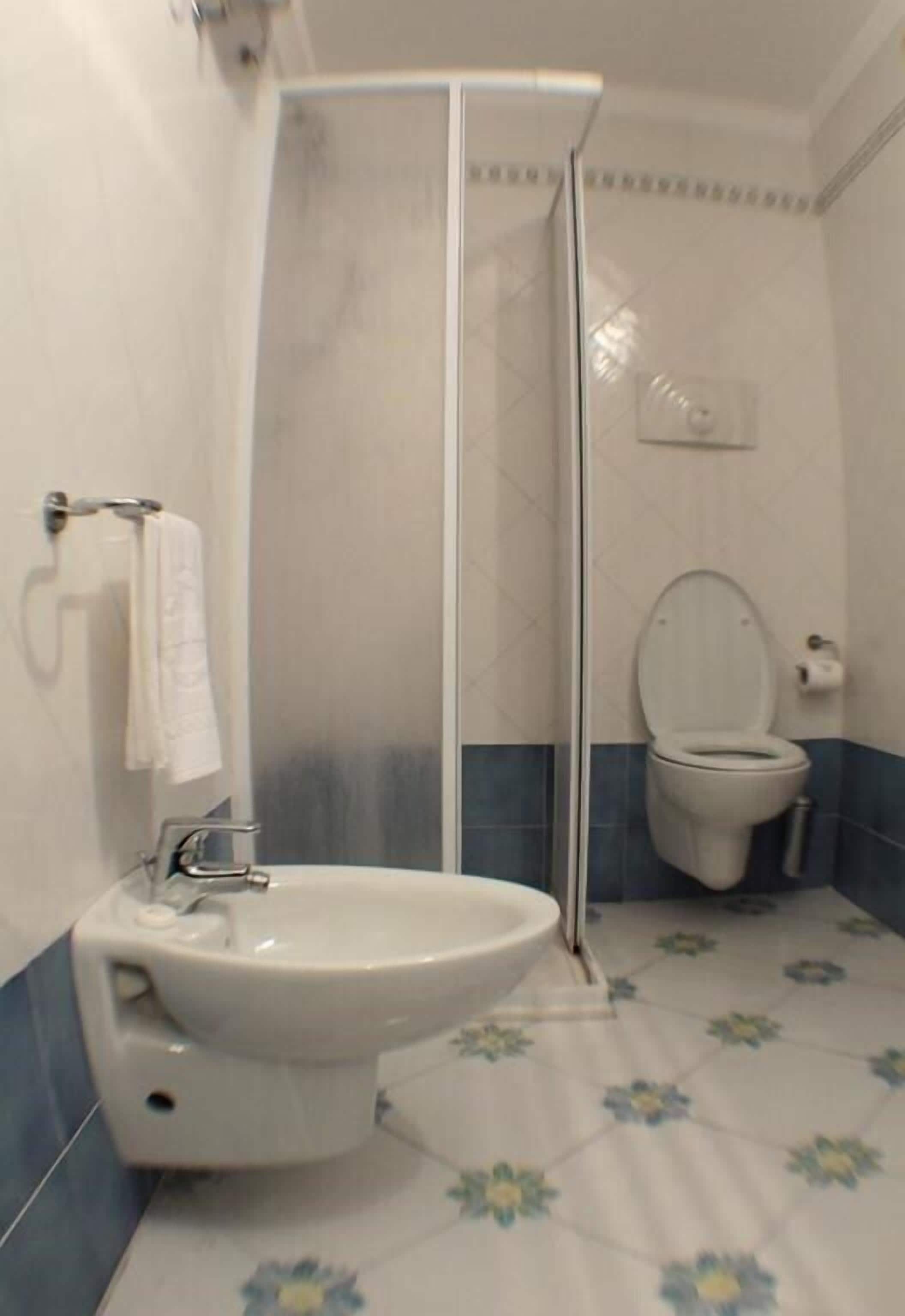 A bathroom with a shower, toilet, and sink.