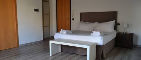 Ein modernes Schlafzimmer mit einem großen Bett, einem Nachttisch und einer Bank.