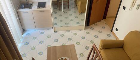 A compact living space with a kitchenette, a dining area, and a sofa.