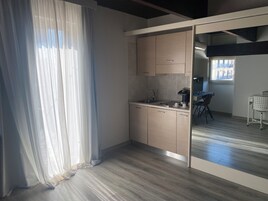 Una cucina moderna con mobili in legno, un lavello e un'area pranzo con una sedia e un tavolo.