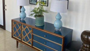 A room with a blue cabinet, two lamps, and a potted plant. - Hotel Ponce de Leon (Coral Gables)