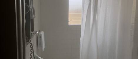 A bathroom with a white sink, a mirror, and a shower curtain.