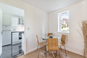 A modern kitchen with white cabinets and a stainless steel refrigerator. - Triple-Train Hub | Step-Free | Parking | Pets (London)
