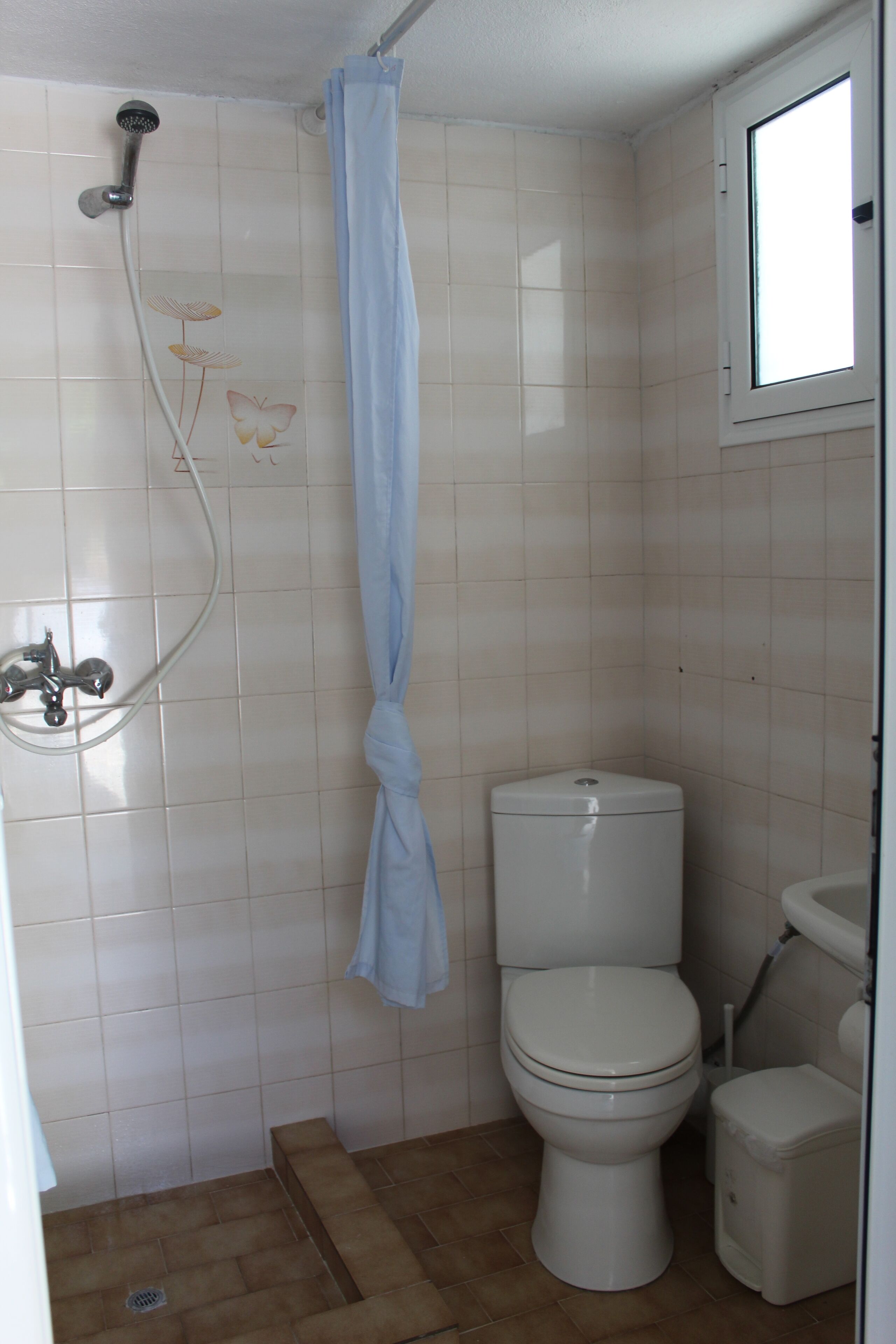 A bathroom with a shower, toilet, and sink.