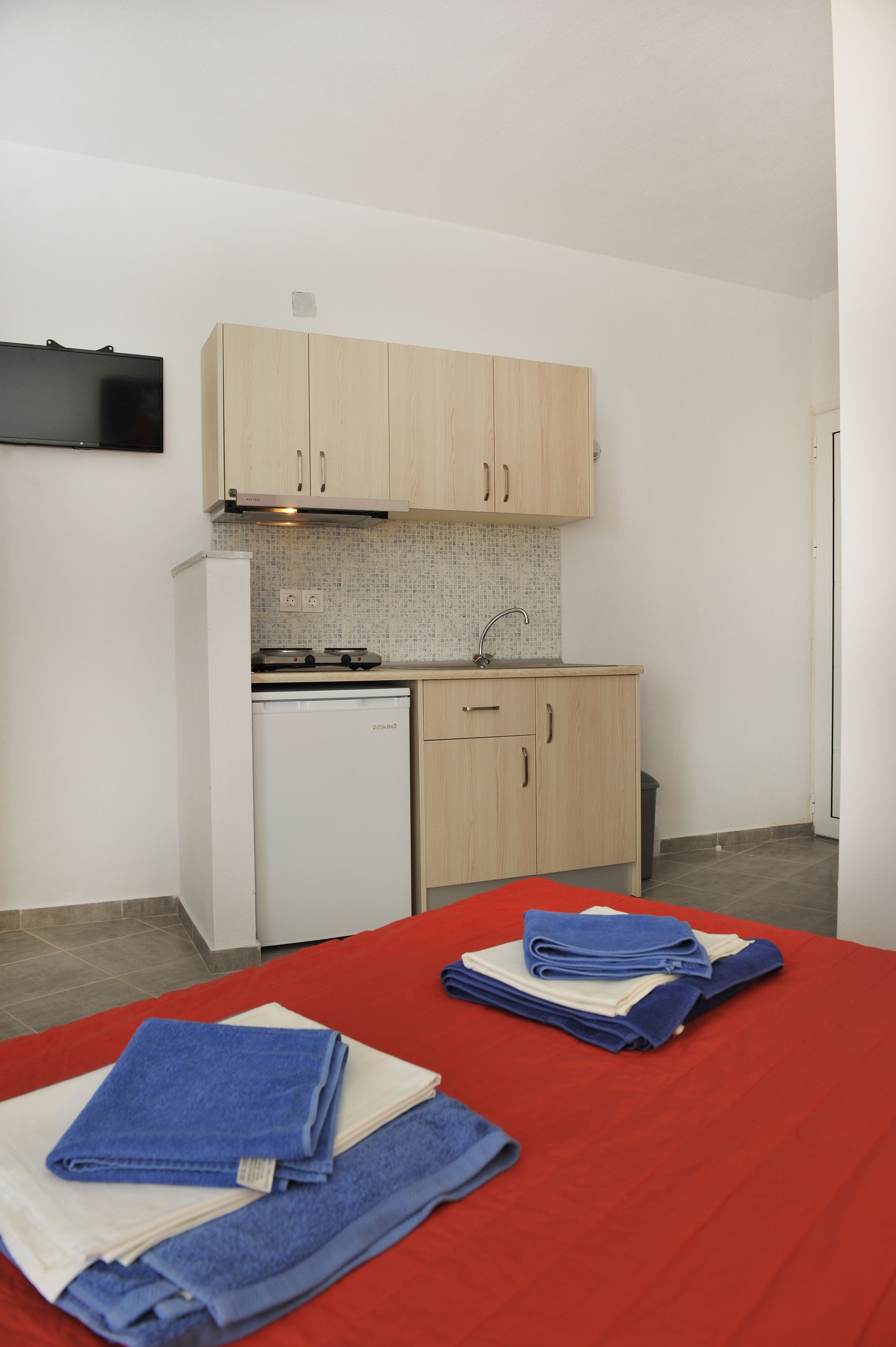 A compact kitchen with wooden cabinets, a built-in dishwasher, and a small countertop.