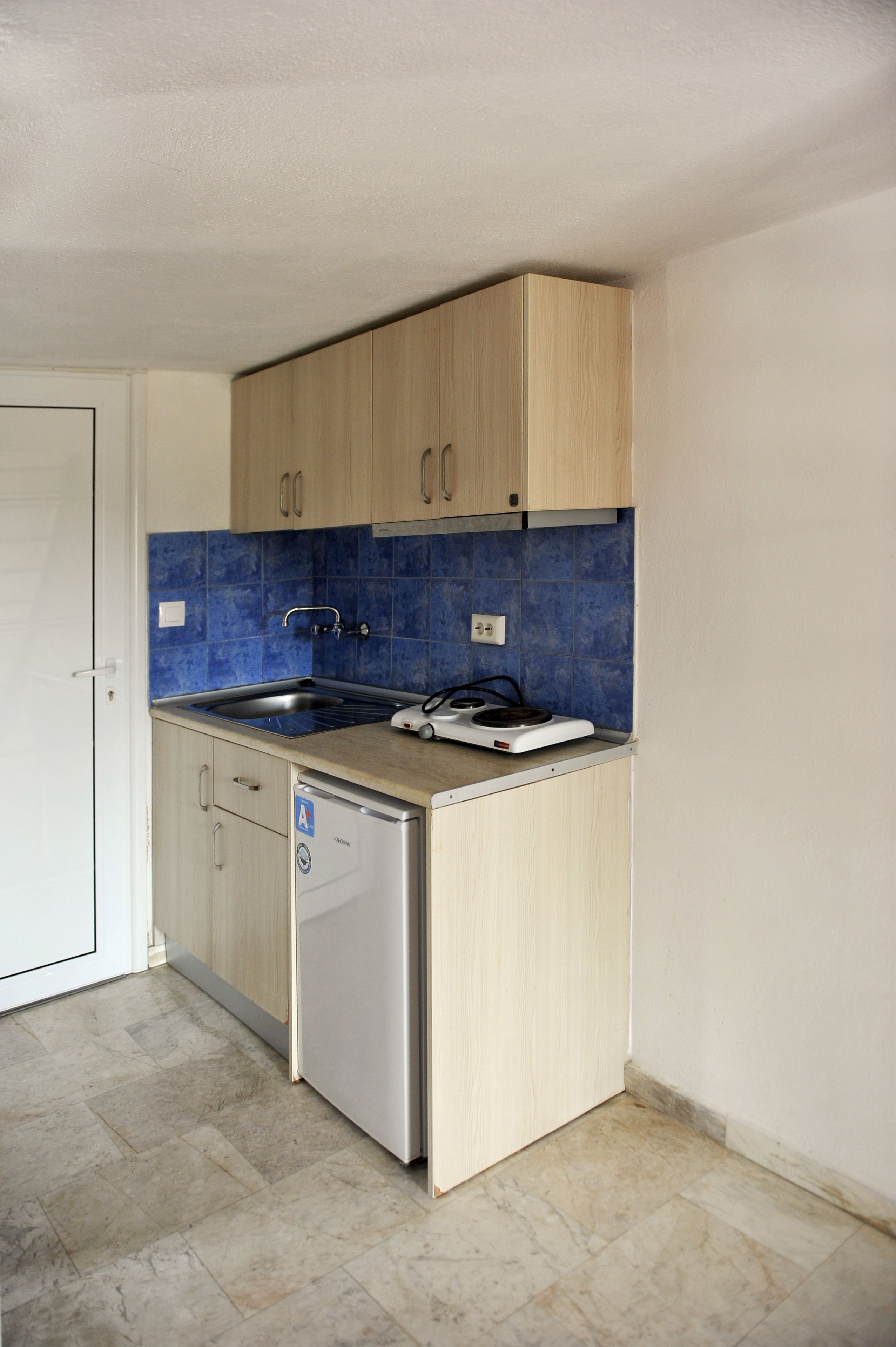 A compact kitchen with a dishwasher, a sink, and a stove.