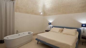 Una camera da letto con un letto grande, una vasca da bagno e due lampade ai lati del letto.