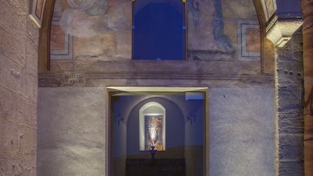 A stone entrance with a glass door, a staircase leading inside, and a mural above. - BV QUARRY MATERA  (Matera)
