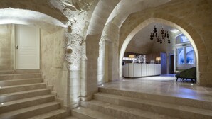 A grand staircase leading to a reception area with a modern kitchen and a view of the outdoors. - BV QUARRY MATERA  (Matera)
