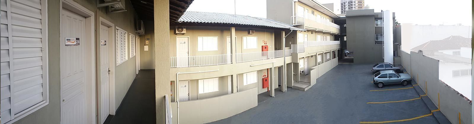 A multi-story building with a parking area.