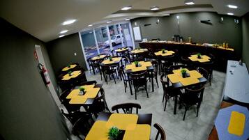 A dining area with multiple tables and chairs, arranged in a spacious layout.