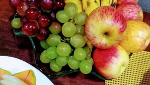 A fruit platter with grapes, bananas, and apples on a table. - Wanna Hotel (Lins)