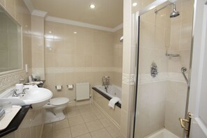 Un baño con lavamanos, inodoro, bañera y ducha.