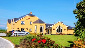 A yellow building with a sign reading "The 9th Lodge" and a smaller building labeled "Guest House." - The 19th Lodge Ballybunion (Ballybunion)