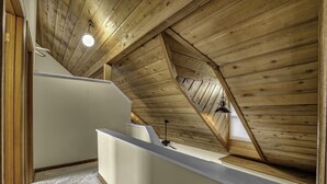 A narrow, sloped ceiling with wooden beams and a small window.