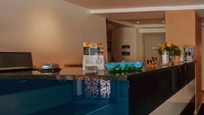 A hotel reception area with a counter, a television, and a decorative vase. - Hotel Drei Kaiserberge (Goeppingen)