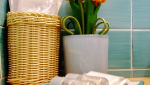 Un comptoir de cuisine avec un panier en osier, une plante en pot aux fleurs jaunes et une assiette avec des salières.