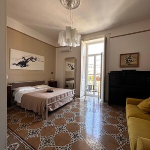 A bedroom with a bed, a mirror, a dresser, and a yellow armchair. - B&B L'Una di Notte (Salerno)