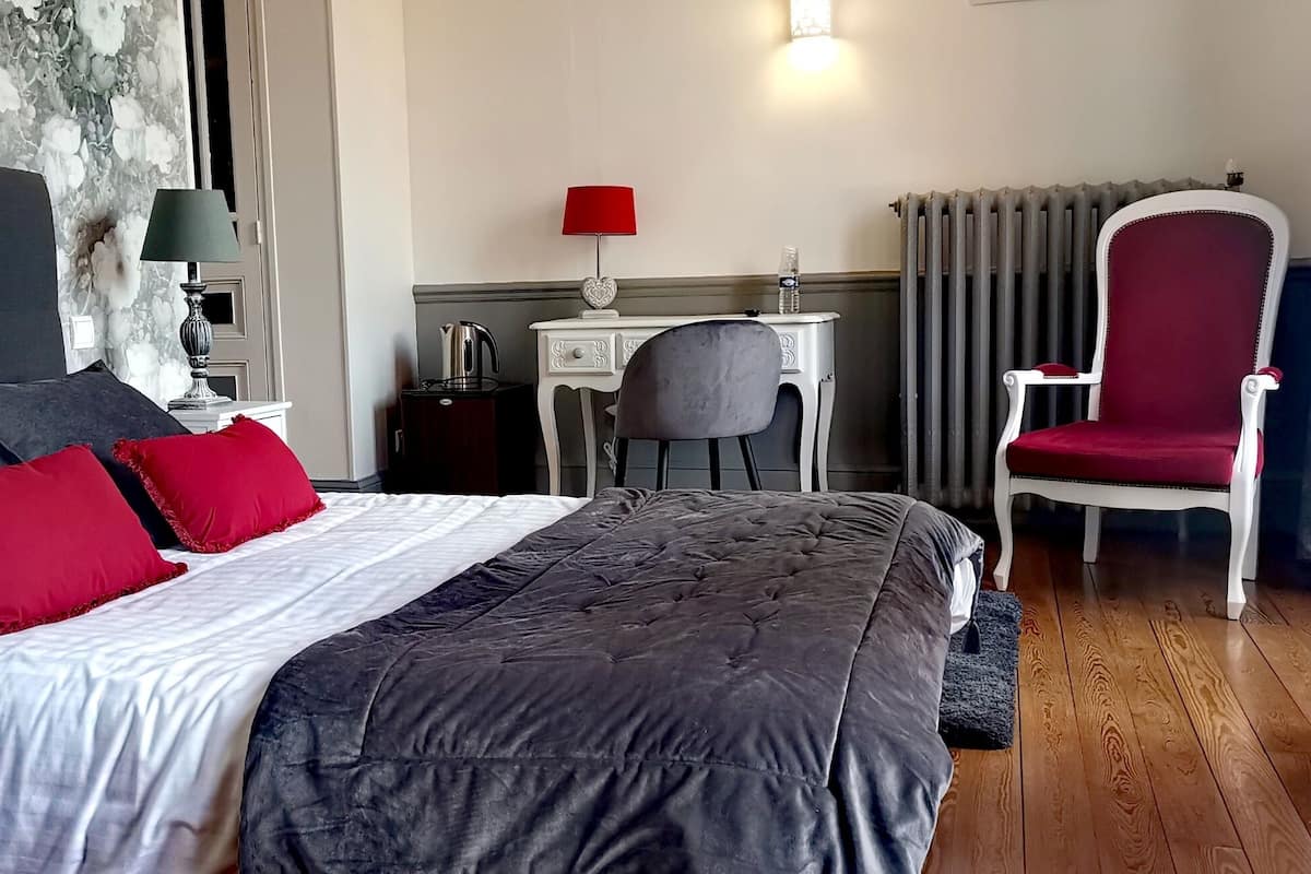 Une chambre bien rangée, avec un lit, un bureau, une chaise et un radiateur.
