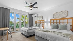 A hotel room with two beds, a desk, and a chair. - Island Studio | Stunning Waterfront Getaway (Condado Lagoon Villas)