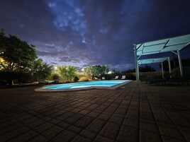 Una piscina al aire libre de temporada, sombrillas, tumbonas